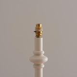 Bevbury Ikat Floor Lamp close-up showing white turned wooden spindle base with brass switched B22 lamp holder, against a plain neutral background.