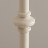 Close-up of the Bevbury Ikat Floor Lamp's turned wooden spindle base in white, showing carved detailing against a neutral background.