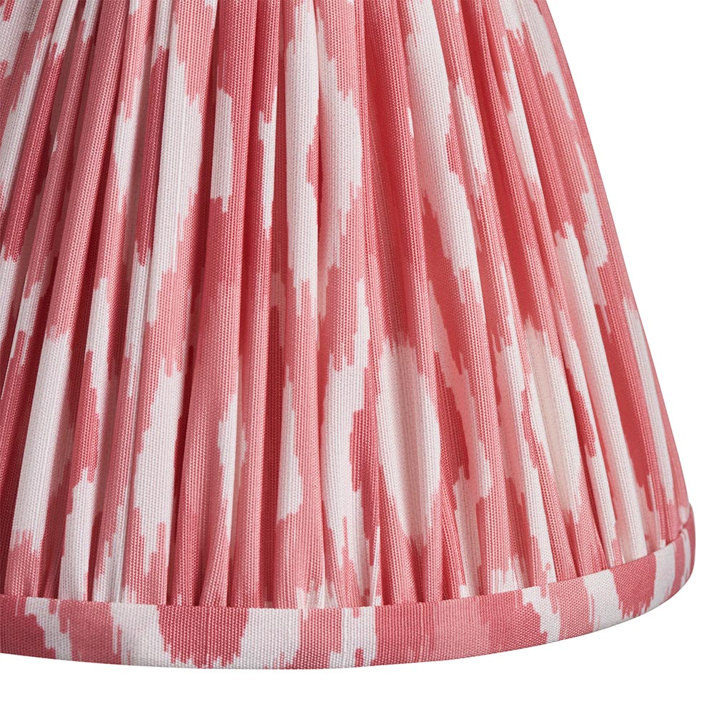 Close-up of the Endon Brackdale Ikat wall light's pleated faux silk shade in coral pink and white ikat print.