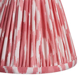 Close-up of the Endon Brackdale Ikat wall light's pleated faux silk shade in coral pink and white ikat print.