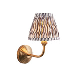 Endon Castgrove Ripple wall light with brushed aged brass stepped backplate, curved arm, and grey rippled pleated fabric tapered shade on white.