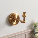 Endon Corven wall light in brushed aged brass with stepped backplate, adjustable knuckle arm and B22 lamp holder, mounted on a pale wall.