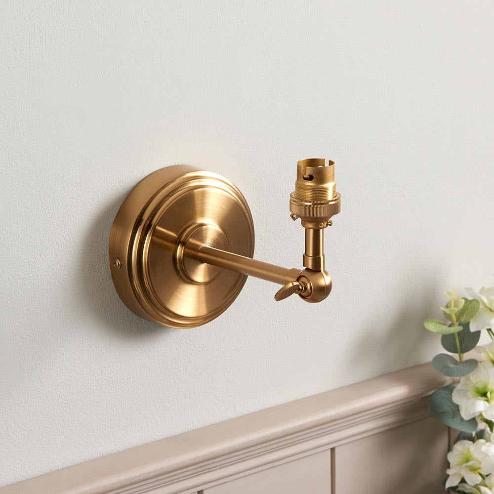 Corven Wall Light in brushed brass, shown without shade, featuring round wall plate, adjustable knuckle arm and B22 lamp holder.