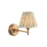 Cliffwood Leaf Wall Light with adjustable brass arm and knuckle joint, featuring a pleated cream and green leaf print fabric shade.