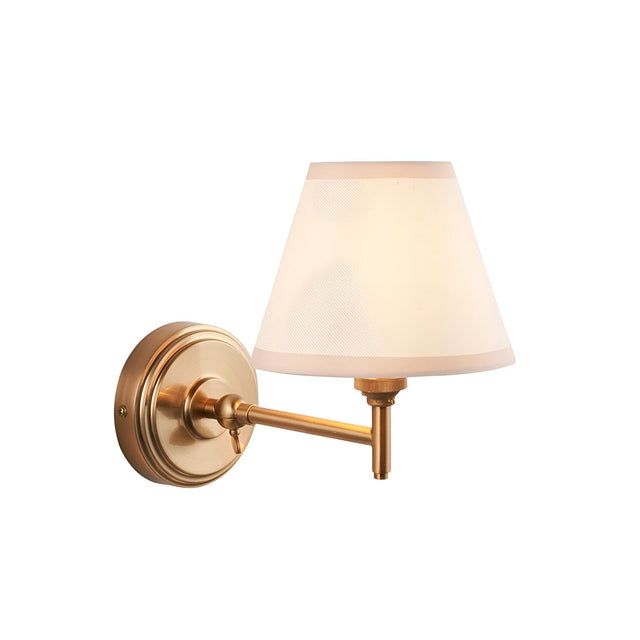 Endon Cliffwood Ivy adjustable wall light in brushed aged brass with a tapered vintage white cotton shade and almond taped edge, on a white background.
