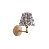 Endon Danemere wall light with natural Ash wood backplate, brushed aged brass adjustable arm, and grey leaf-print pleated fabric shade on a white background.