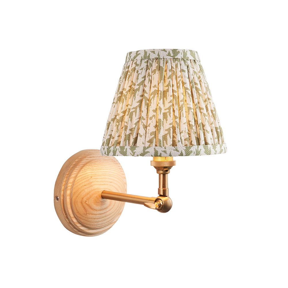 Endon Danemere wall light with natural Ash wood back, brushed aged brass adjustable arm, and green leaf-print pleated fabric shade on a white background.