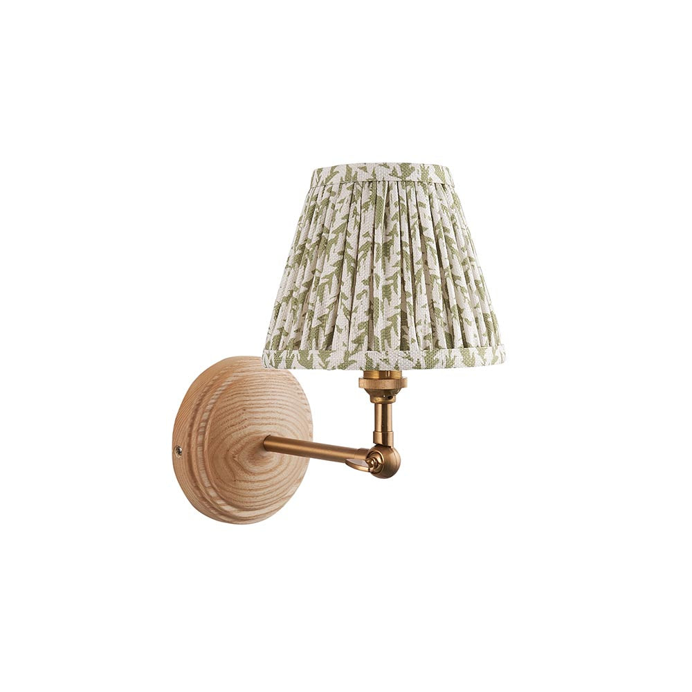 Endon Danemere wall light with natural Ash wood back, adjustable brushed aged brass arm and green leaf-print pleated faux linen shade.