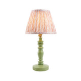 Endon Aldworth Leaf table lamp with green turned wood spindle base, brass B22 lampholder and pleated pink leaf-print fabric shade on a white background.