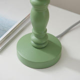 Close-up of the Endon Aldworth Leaf table lamp base, showing the green satin painted turned wooden spindle on a round plinth with grey braided flex.