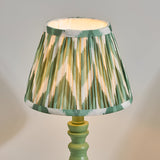 Endon Aldworth table lamp with green turned wood spindle base and handmade pleated Zigzag faux silk shade in green, olive and cream.