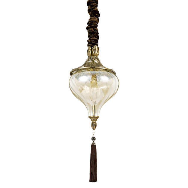 The Daley 1 Light Glass Pendant - Brass is a vintage-inspired lighting fixture featuring an ornate gold decorative top and a clear handcrafted glass lampshade. It is elegantly designed with a long brown tassel, sophisticated brown cord covering, and subtle brass accents to enhance its classy appearance.