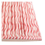 Close-up of the Endon Bevbury Ripple floor lamp shade, a pleated faux linen shade with pink wavy pattern and striped taped edge trim.