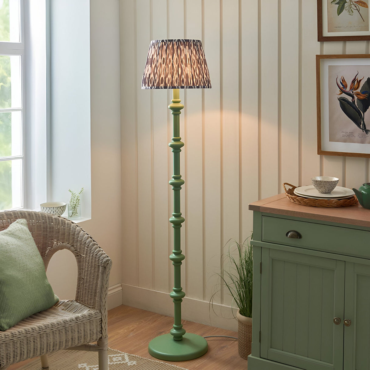 Endon Bevbury floor lamp with green turned wood spindle base and grey patterned Ikat pleated shade, styled in a cream living room corner.