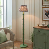 Endon Bevbury floor lamp with green turned wood spindle base and grey patterned Ikat pleated shade, styled in a cream living room corner.