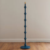 Endon Bevbury Ripple floor lamp base in blue turned wood with spindle detailing and brass B22 holder, shown on wood flooring against a neutral wall.