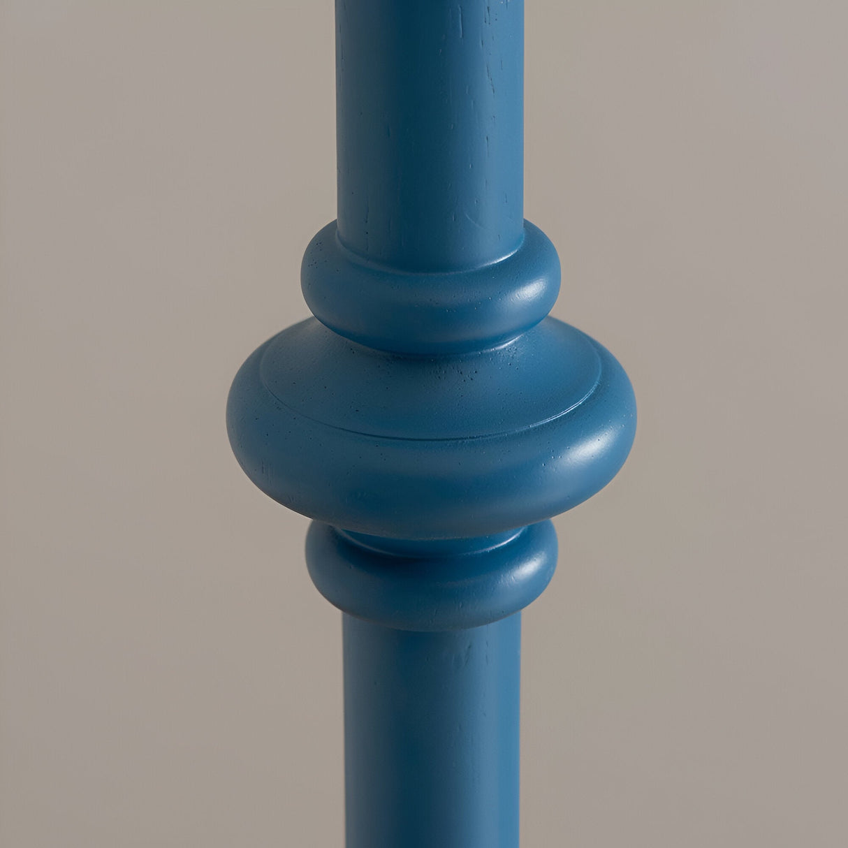 Close-up of the Endon Bevbury floor lamp's hand-turned wooden spindle base in marlin blue, showing rounded ring detailing against a neutral background.