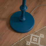 Close-up of the Endon Bevbury Ripple floor lamp's marlin blue turned wooden spindle base with grey braided flex on wood flooring beside a woven rug.