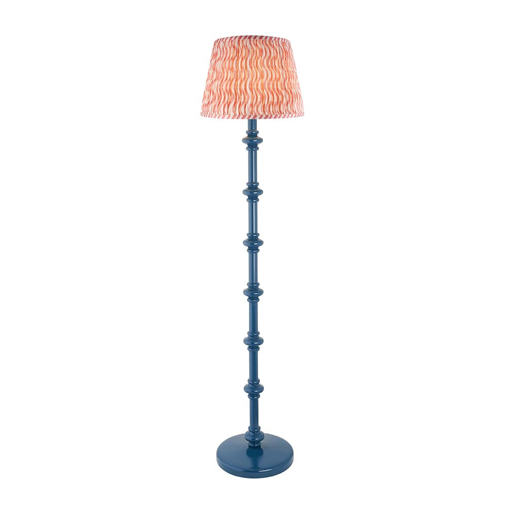 Endon Bevbury Ripple floor lamp with a blue turned wood spindle base and a pink and coral rippled pleated faux linen shade on a white background.