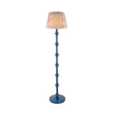 Endon Bevbury Ikat floor lamp with blue turned wood spindle base and pleated natural patterned faux silk shade on a plain white background.