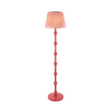 Endon Bevbury Ripple floor lamp with coral turned wooden spindle base and pink patterned faux linen tapered shade on a plain background.
