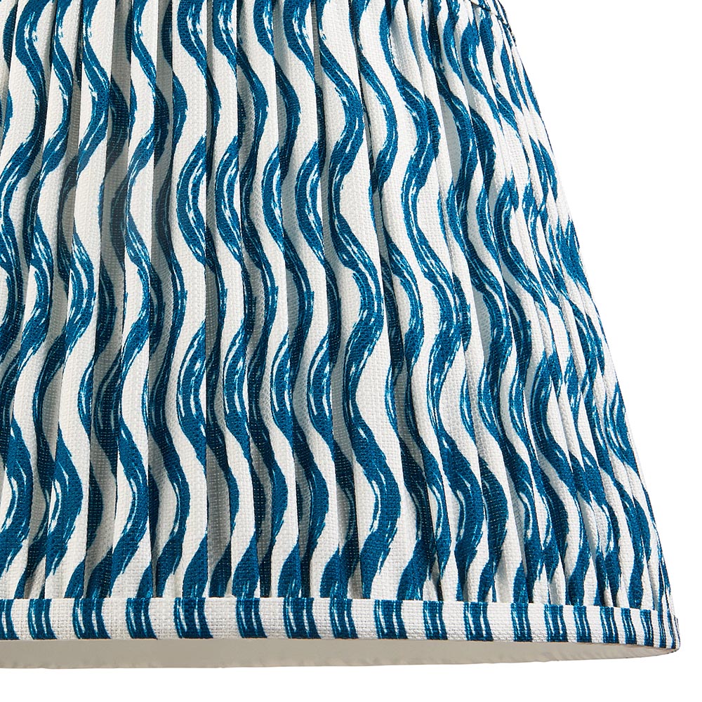 Close-up of the Endon Brenleigh Ripple floor lamp shade, a gathered pleat faux linen design with a blue wave pattern on white and taped edging.