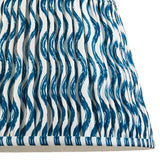 Close-up of the Endon Brenleigh Ripple floor lamp shade, a gathered pleat faux linen design with a blue wave pattern on white and taped edging.