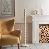 Endon Brenleigh stacked sphere floor lamp in white beside a mustard armchair and white fireplace with stacked logs, shown without shade fitted.