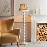 Endon Brenleigh floor lamp with white stacked sphere base and grey Ikat pleated shade, beside a mustard armchair and white fireplace with stacked logs.