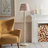 Endon Brenleigh stacked sphere floor lamp in white with a pink Ikat pleated shade, beside a mustard armchair and white fireplace stacked with logs.
