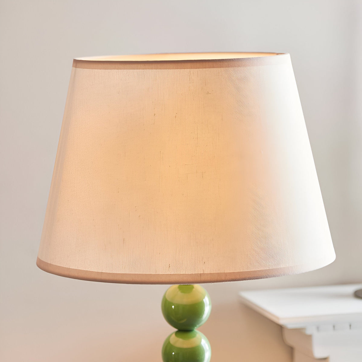 Endon Brenleigh floor lamp detail showing the tapered vintage white Ivy fabric shade above a glossy Cotswold green stacked sphere base.