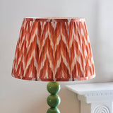 Brenleigh Zigzag Floor Lamp with green gloss stacked sphere base and pleated rust-orange zigzag print shade, shown against a plain light background.