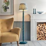 Endon Brenleigh floor lamp in marlin blue with stacked sphere base and Ripple pleated shade, beside a mustard armchair and white fireplace.