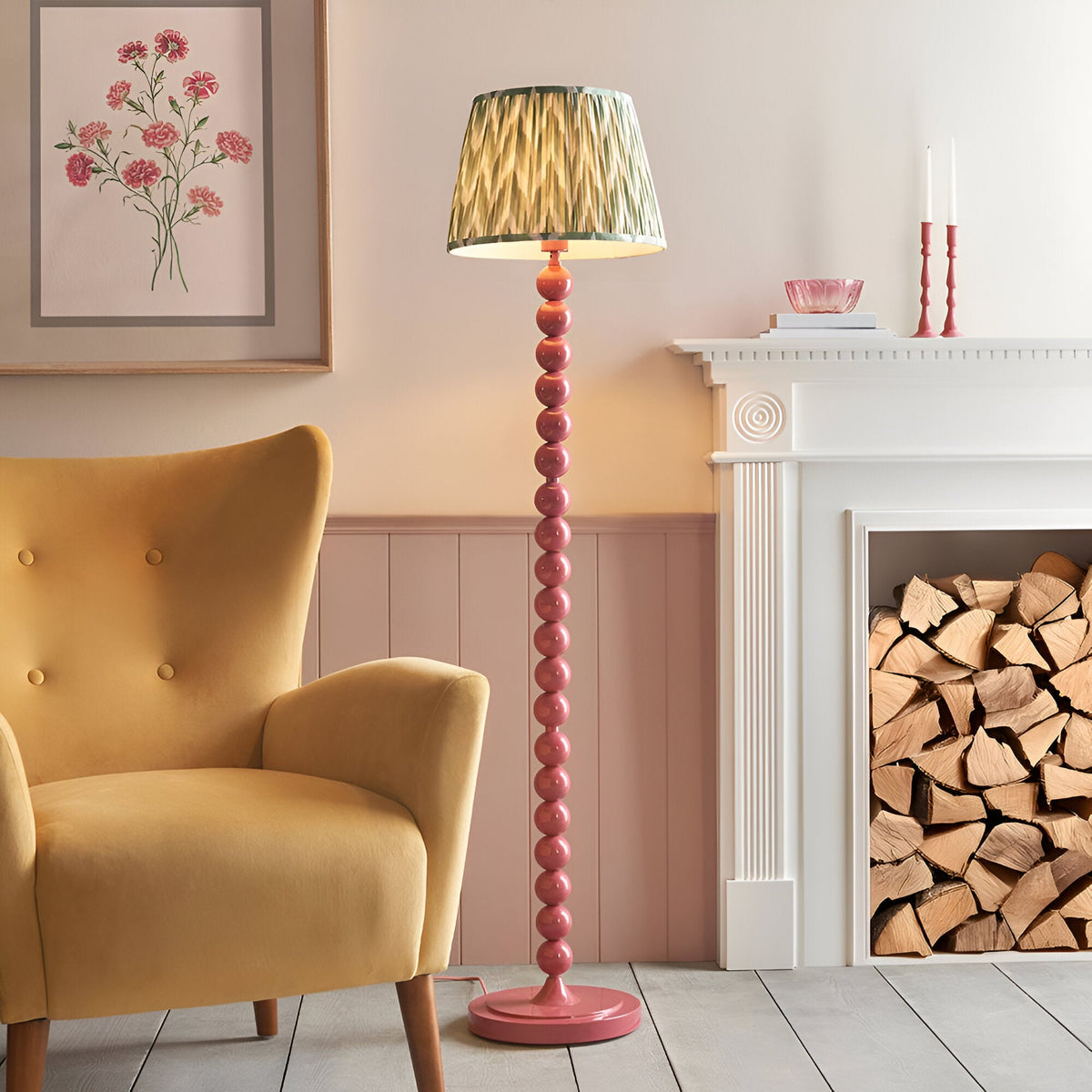 Endon Brenleigh floor lamp with stacked pink gloss sphere base and green zigzag pleated shade, beside a yellow armchair and white fireplace.