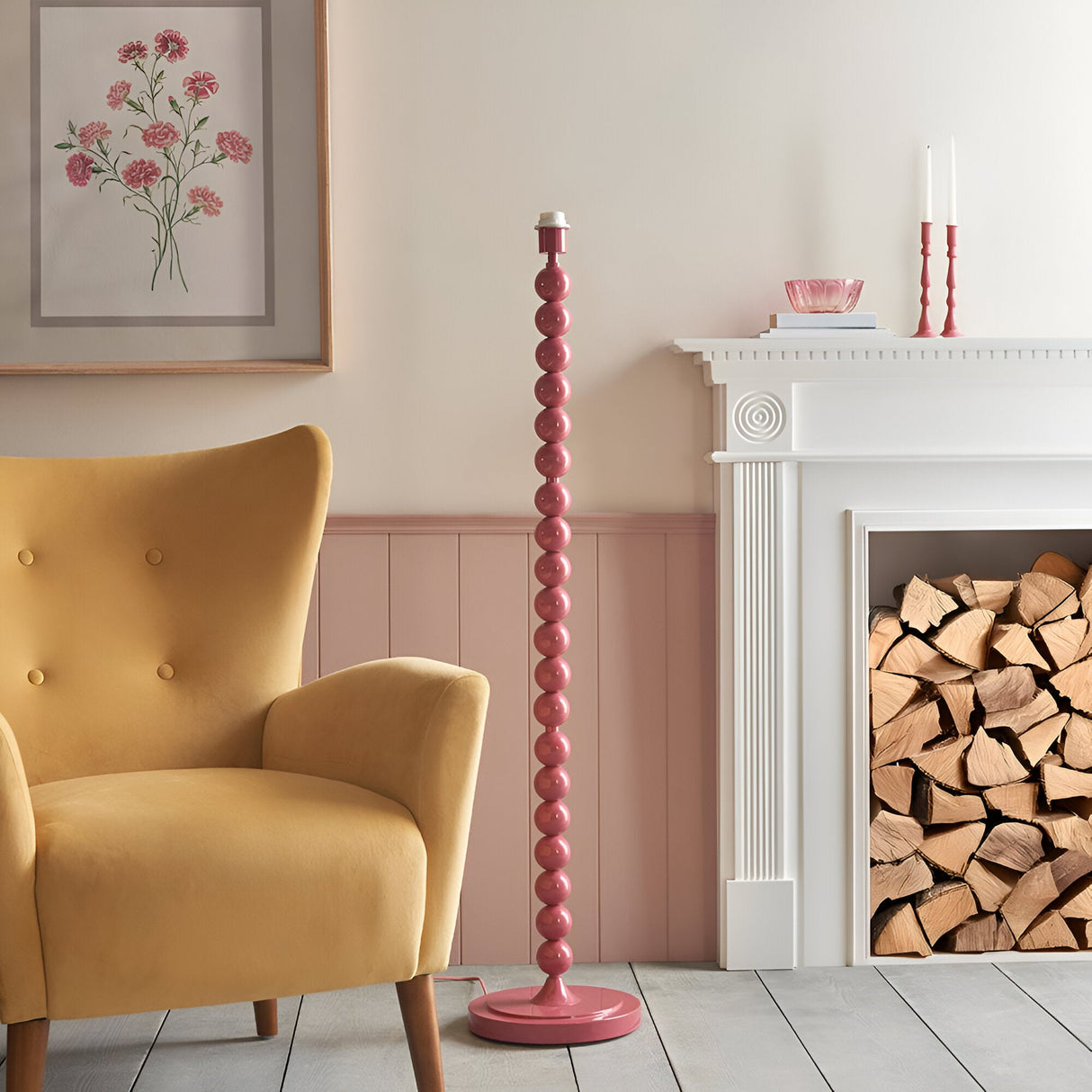 Endon Brenleigh pink stacked sphere floor lamp beside a mustard velvet armchair, pink panelled wall and white fireplace with stacked logs.