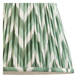 Close-up of the Endon Brenleigh floor lamp's 35cm Zigzag shade in green and white, showing the gathered pleat faux silk with taped edge detail.