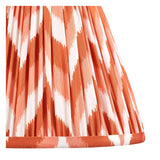 Close-up of the Endon Amberley Zigzag table lamp shade, showing pleated apricot orange and white ikat-print faux silk fabric.