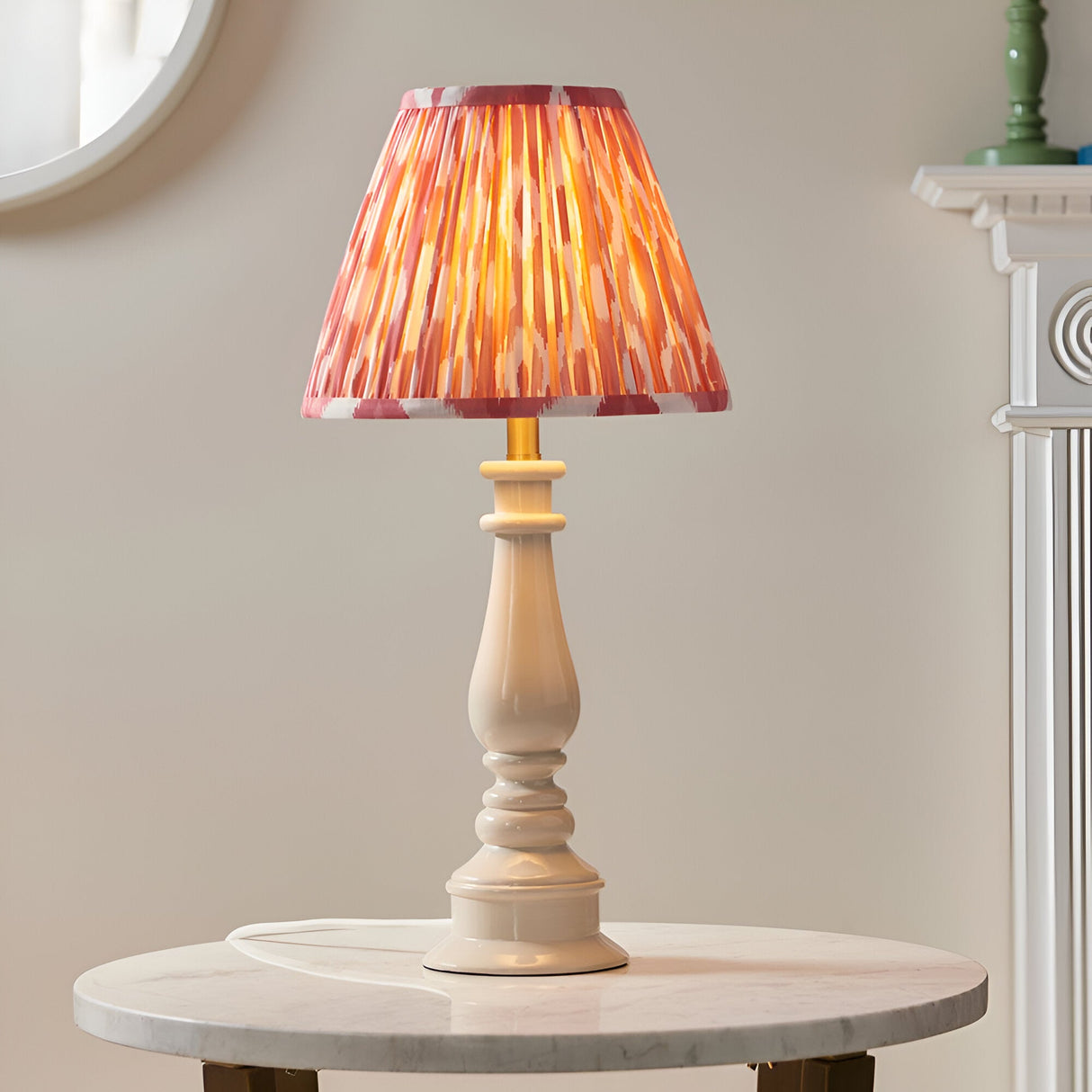 Endon Carlworth Ikat table lamp in almond and coral with a gloss turned resin spindle base and pleated ikat shade, on a marble side table.