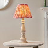 Endon Carlworth Ikat table lamp in almond and coral with a gloss turned resin spindle base and pleated ikat shade, on a marble side table.