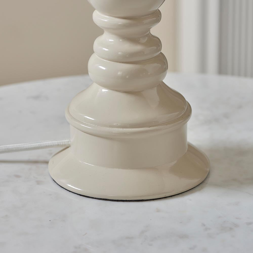 Close-up of the Endon Carlworth Ikat table lamp base in almond high gloss resin, with turned spindle shaping and braided flex, on a marble surface.