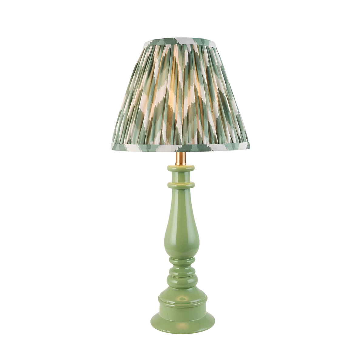 Carlworth Zigzag Table Lamp with a green resin spindle base and a pleated zigzag-patterned shade in green, cream and gold, shown on a plain white background.