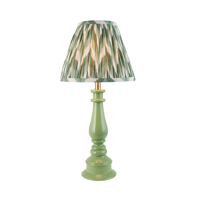 Carlworth Zigzag Table Lamp with a green resin spindle base and a pleated zigzag-patterned shade in green, cream and gold, shown on a plain white background.