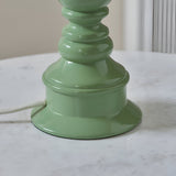 Carlworth Zigzag Table Lamp base close-up in Cotswold Green resin with turned spindle shape and white fabric cord, shown on a marble surface.