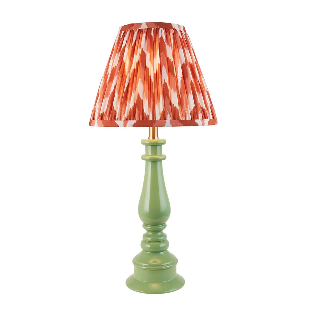 Carlworth Zigzag Table Lamp with a glossy green resin spindle base and a pleated apricot zigzag-print shade, shown on a plain white background.