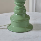 Close-up of the Endon Carlworth Ivy table lamp's glossy green turned resin base with white braided flex, set on a marble surface.