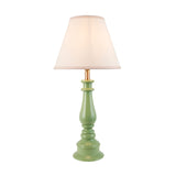 Endon Carlworth Ivy table lamp with a green high gloss turned resin spindle base, brass fitting, and tapered vintage white fabric shade on a plain background.