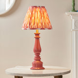 Endon Carlworth Ikat table lamp in pink clay with a turned gloss resin spindle base and pleated coral Ikat shade, on a marble side table.