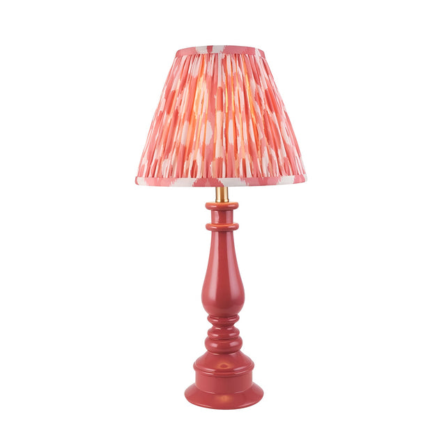 Endon Carlworth Ikat table lamp with pink clay turned resin spindle base and pleated coral ikat faux silk shade on a white background.
