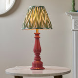 Carlworth Zigzag Table Lamp with pink clay resin spindle base and gathered green zigzag-print pleated shade, shown on a marble side table.