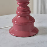Close-up of the Carlworth Zigzag Table Lamp base in glossy pink clay resin with a turned, spindle-style design on a marble surface.